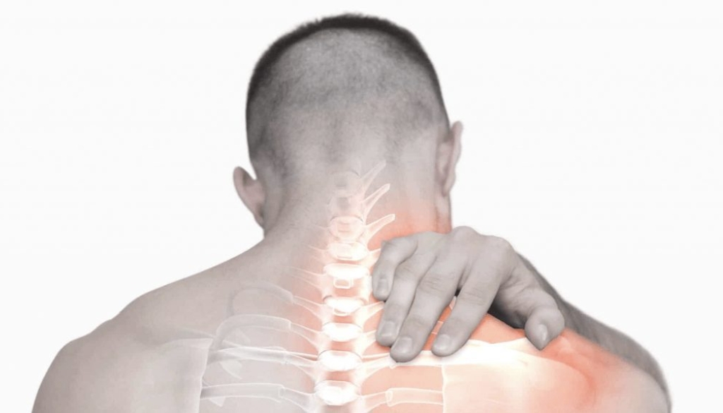 Male physical therapist applying target pressure to a patient's upper back and thoracic spine area during a clinical rehabilitation session