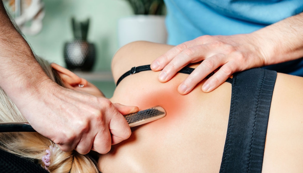 Physiotherapist performing targeted manual myofascial trigger point release therapy on a back muscle