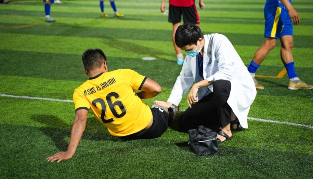 Sports physiotherapist applying targeted therapeutic joint mobilization on an athlete's knee