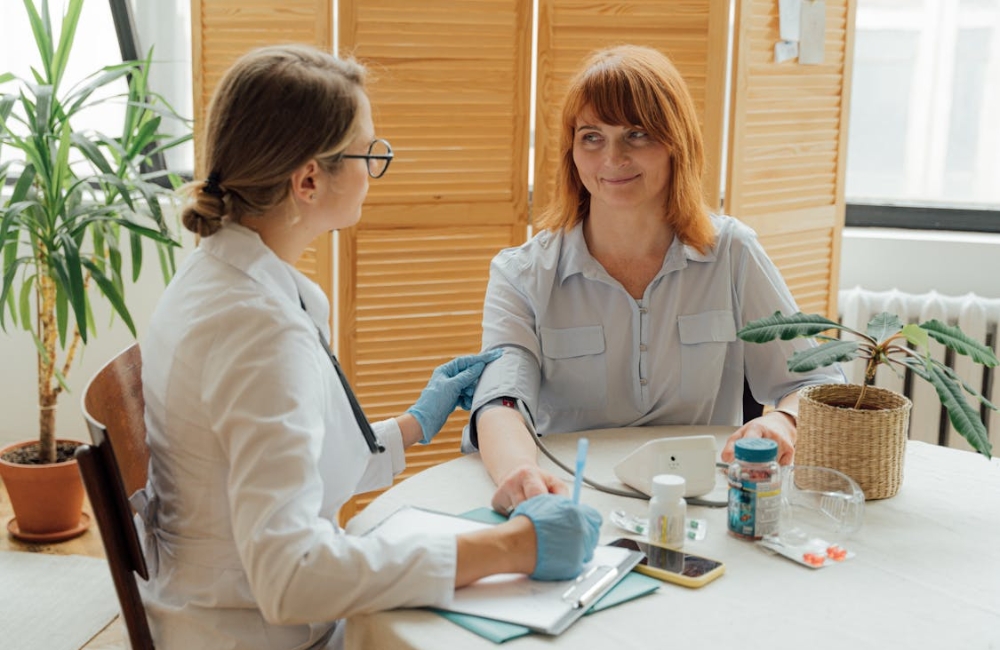 A kind physician checking a young child's temperature while talking gently with the mother in a clinic