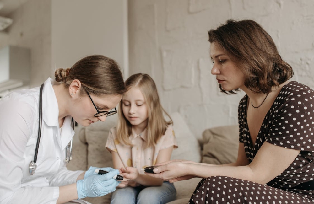 Medical consultant holding up a digital glucometer reading during a regular diabetes health tracking checkup with a patient